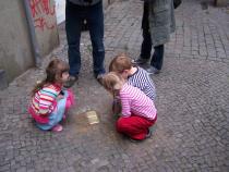 Kinder betrachten die Stolpersteine in der Donaustraße 11 am Tag der Verlegung.